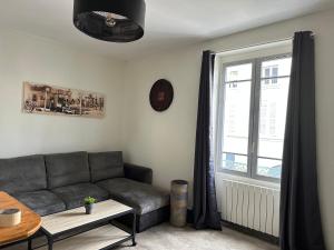 a living room with a couch and a window at F2 hyper centre ville Lons in Lons-le-Saunier +2 photos