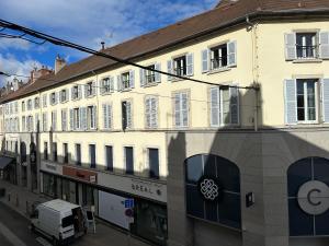 a large white building on a city street at F2 hyper centre ville Lons in Lons-le-Saunier