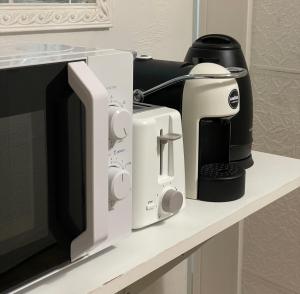 a microwave and a coffee maker on a counter at Blue Iris Home in Sanremo