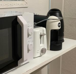 un forno a microonde e una macchinetta del caffè su un bancone di Blue Iris Home Sanremo a Sanremo