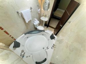 a bathroom with a bath tub and a sink at Departamento con jacuzzi, balcón, lavadora y garage in Ambato