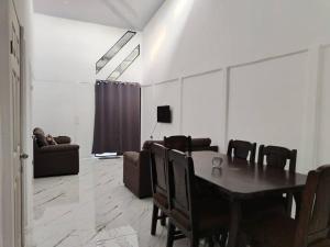 a dining room with a table and chairs and a couch at Casa Cala in Bribri