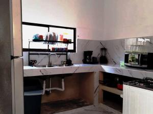 a kitchen with a sink and a microwave at Casa Cala in Bribri