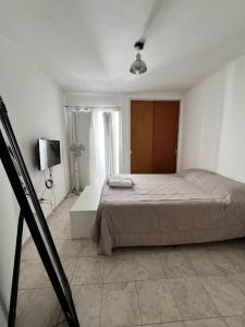 um quarto com uma cama num quarto branco em Departamento Luminoso en Nueva Cordoba em Córdoba