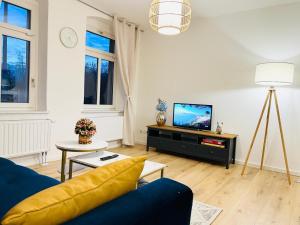 a living room with a blue couch and a tv at Twenty Five Apartment bei Dresden - free Parking, Netflix & Coffee Machine in Heidenau