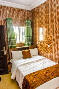 een slaapkamer met een groot bed en groene gordijnen bij E45 Hotels and Suites in Owerri