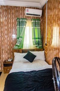 sypialnia z łóżkiem i oknem w pokoju w obiekcie E45 Hotels and Suites w Owerri
