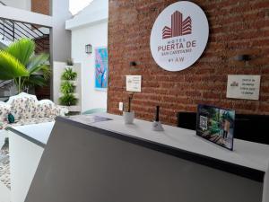 a reception desk in a room with a brick wall at Aw Hotel Puerta de San Cayetano in Cali