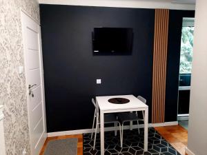 ヘウムにあるNoclegi Centrum Chełmのテーブルと壁にテレビが掛かっている部屋