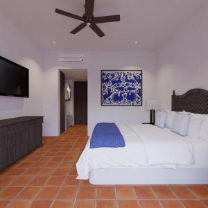 um quarto com uma grande cama branca e uma televisão de ecrã plano em Tropicana Los Cabos em San José del Cabo