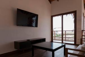uma sala de estar com uma mesa e uma televisão na parede em ZAFIRO CHINCHA® Casa de Lujo Piscina frente al mar em Casa Blanca