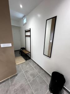 een kamer met een spiegel en een stoel aan een muur bij Le Japandi - Cosyloc Agency - Aux Portes de Paris in Pantin