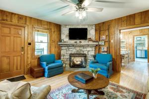 un salon avec des chaises bleues et une cheminée dans l'établissement Peaceful Hendersonville Cabin - Hot Tub and Fire Pit, à Hendersonville