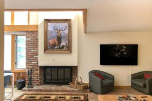 a living room with a fireplace and a painting of a deer at Mountain Haven Retreat in Stratton Acres