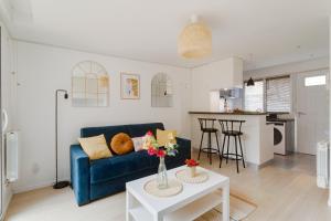 a living room with a blue couch and a table at P'tit Garden / JO 2024 / Paris/ Stade de FRANCE in Aulnay-sous-Bois