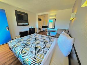 Motel 6-Palm Desert, CA - Palm Springs Area في برمودا ديونز: غرفة نوم مع سرير وغرفة معيشة