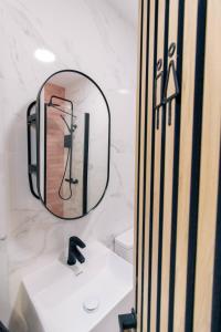 a bathroom with a mirror and a faucet on a sink at Koala Hostel Mercado in Alicante