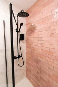 a shower in a bathroom with a brick wall at Koala Hostel Mercado in Alicante