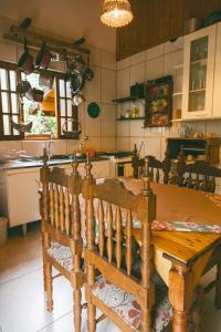 cocina con mesa de madera y comedor en Casa Pedacinho de Céu com banheira de hidromassagem e lareira, en São Bento do Sapucaí