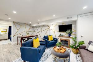 ein Wohnzimmer mit 2 blauen Sofas und einem Kamin in der Unterkunft Downtown Retreat - Your Urban Oasis in College Park