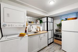 cocina blanca con fregadero y nevera en Downtown Retreat - Your Urban Oasis, en College Park