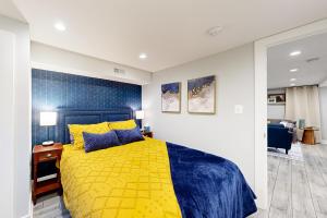 um quarto com uma cama amarela e uma cabeceira azul em Downtown Retreat - Your Urban Oasis em College Park