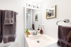 a bathroom with a sink and a mirror at Downtown Retreat - Your Urban Oasis in College Park +4 photos