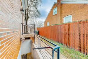 an orange brick building with a staircase next to a fence at Downtown Retreat - Your Urban Oasis in College Park