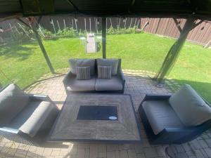 two leather couches sitting under an umbrella in a yard at APARTMENT B 2 BEDROOM in Brampton