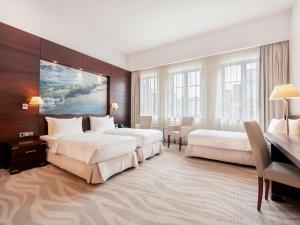 a hotel room with two beds and a desk at Radisson Blu Hotel, Gdańsk in Gdańsk +93 photos