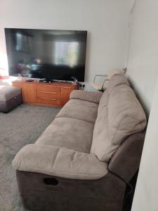 a brown couch in a living room with a television at Loving Home to Stay with Rear Garden and Patio in Rochdale