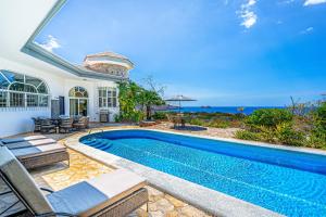 a villa with a swimming pool and a house at Casa Reina Main House & Casita in Playa Hermosa