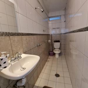 a bathroom with a sink and a toilet at Depa Púrpura Caracol in San Antonio de la Cal