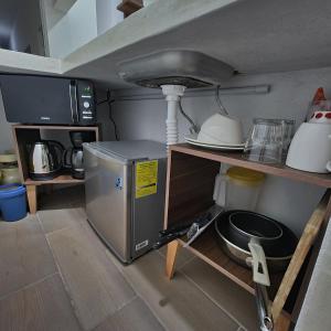 a small kitchen with a microwave and a counter top at Depa Púrpura Caracol in San Antonio de la Cal