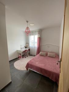 een slaapkamer met een bed, een bureau en een raam bij Maison au cœur des vignes in Bédarrides