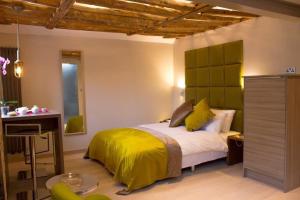 um quarto com uma cama com um cobertor amarelo em Henry's em Oxford