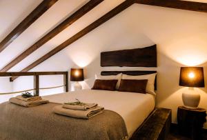 a bedroom with a large bed with towels on it at Monte do Alento - Castro da Cola in Alcaria
