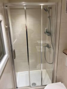 La salle de bains est pourvue d'une douche avec une porte en verre. dans l'établissement Superbe Studio proche paris à Cachan au pied du RER B, à Cachan