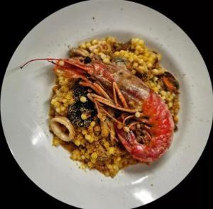 une plaque blanche de nourriture avec une crevette sur un plat dans l'établissement S'INCONTRU A CA' DELL' ALPINO, à Borra