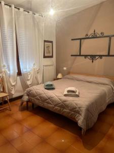 Borra的住宿－S'INCONTRU A CA' DELL' ALPINO，卧室配有一张带白色窗帘的大床