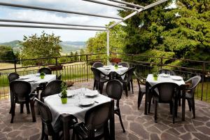 un restaurante con mesas y sillas en un balcón en S'INCONTRU A CA' DELL' ALPINO en Borra