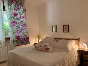 a bedroom with a bed with white sheets and a window at Cala dei Pirati in Punta Ala