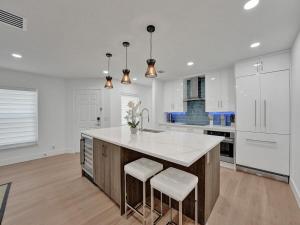 a kitchen with a large island with white counter tops at Peaceful Villa Lauren in Delray Beach