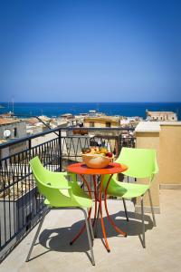 a table and chairs on a balcony with a view at Affittacamere le scale in Castellammare del Golfo