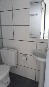 uma casa de banho branca com um WC e um lavatório em Dolaço na Chapada- Hospedagem em Alto Paraíso de Goiás