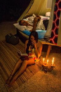 a woman sitting on the ground with a book and candles at Aconchego Gaia in Alter do Chao