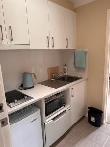 una pequeña cocina con fregadero y microondas en Blue Bay Studio, en Port Macquarie