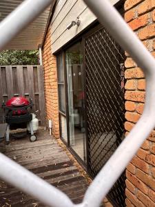 een patio met een grill en een bakstenen muur bij Blue Bay Studio in Port Macquarie