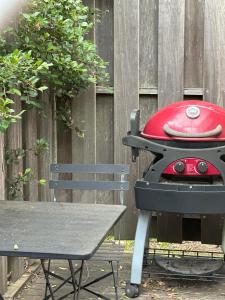 a red grill sitting next to a picnic table at Blue Bay Studio in Port Macquarie