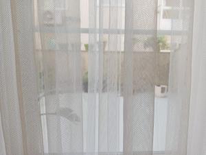 uma vista para uma janela com cortinas brancas em LA MACETA em Vilagarcía de Arousa